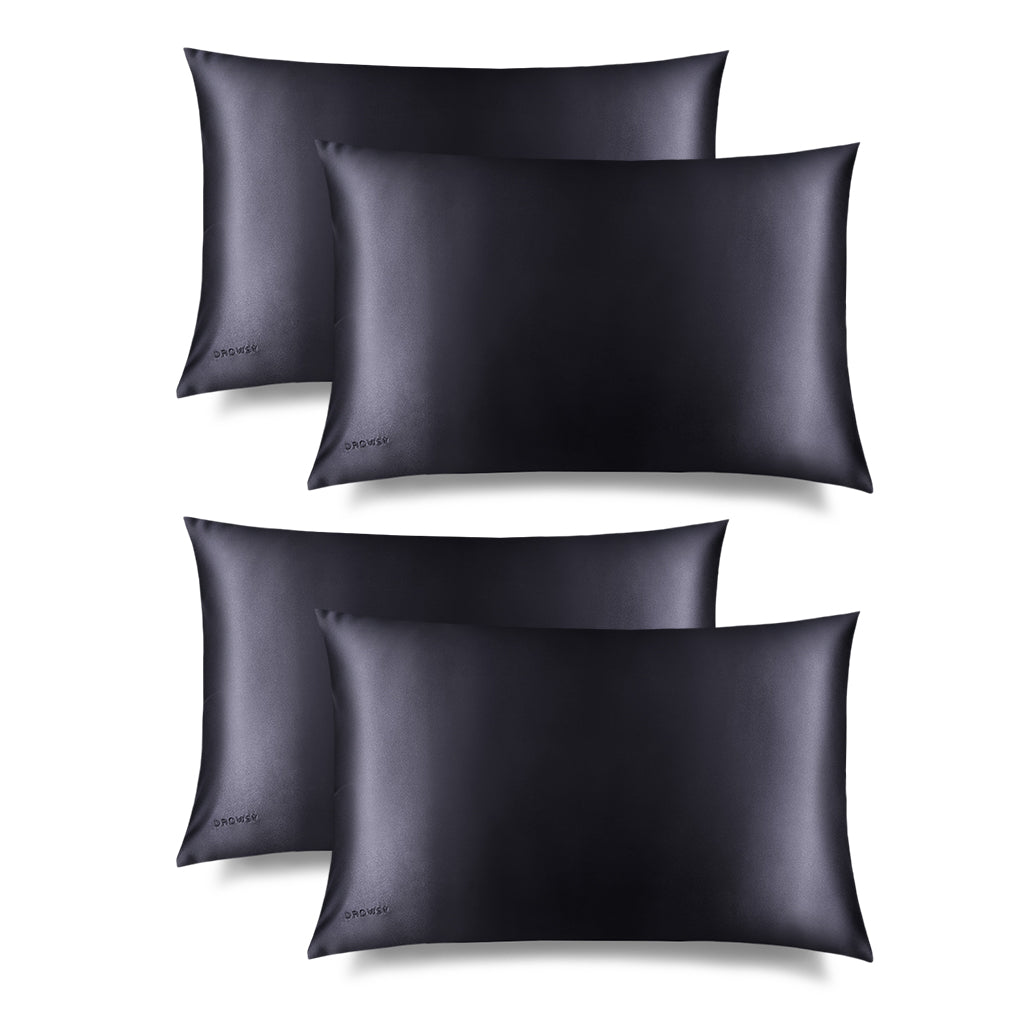 Four Moonlight Shadow Silk Pillowcases by us.drowsysleepco are arranged in two rows on a white background. Each has a smooth, shiny texture and a subtle corner logo, making them perfect for skincare routines.