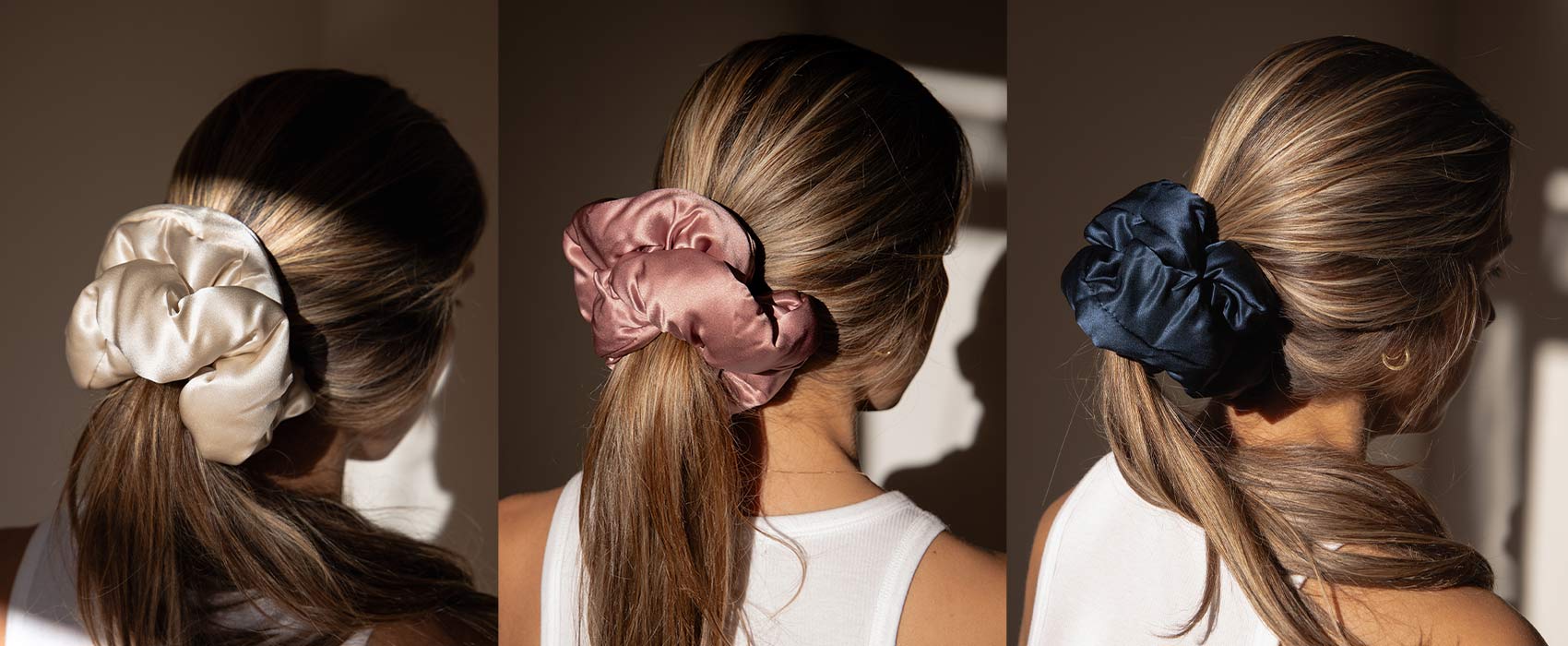 Three images side by side show a woman with long, light brown hair wearing large satin scrunchies in different colors: cream, rose gold, and navy blue, each holding her low ponytail.