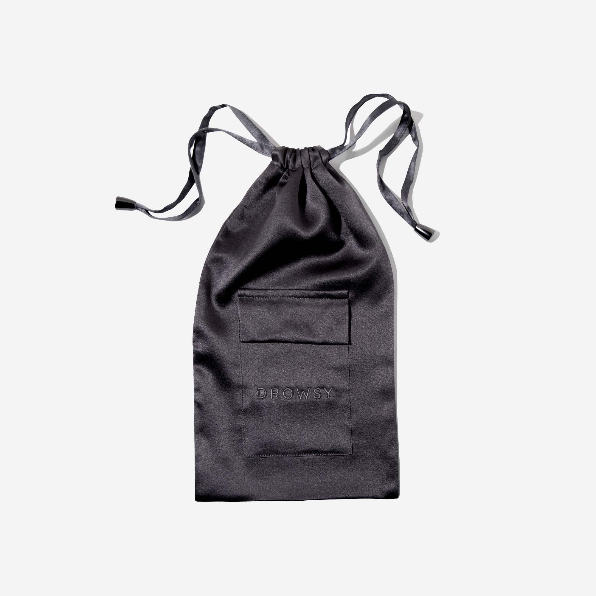 A black satin drawstring pouch with a front pocket and the word DROWSY embroidered on it, displayed against a plain white background.