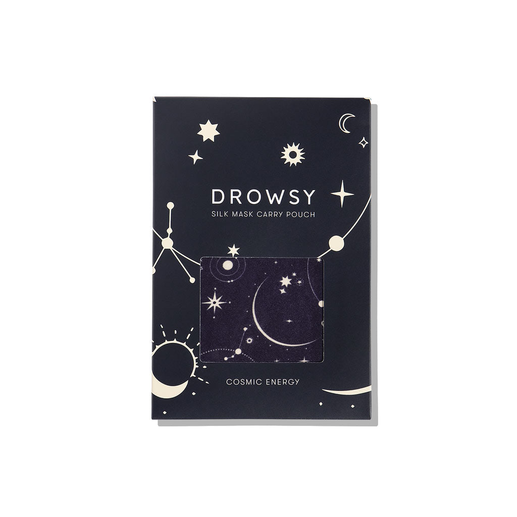A dark blue box from us.drowsysleepco labeled Cosmic Energy Silk Carry Pouch features celestial stars, planets, and moons. A small window displays the pure mulberry silk pouch inside. The bottom text reads Cosmic Energy.