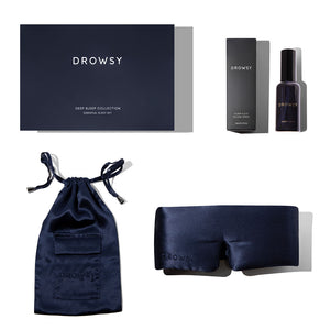 The us.drowsysleepco Midnight Blue - Deep Sleep Collection includes a luxury silk sleep mask, blue silk pouch, deep sleep pillow spray with box, and a large branded box—all elegantly displayed on a white background.