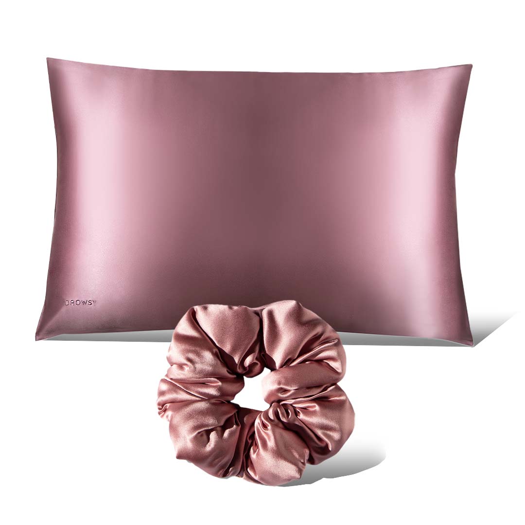 The drowsysleepco Perfect Hair Bundle Pink Damask Rose, featuring a shiny pink silk pillowcase and matching scrunchie, is displayed against a crisp white background.