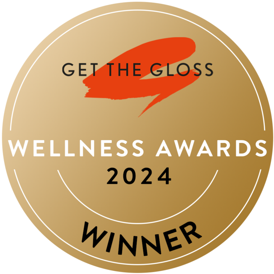 Gold circular badge with the text Get The Gloss Wellness Awards 2024 Winner and a red brushstroke logo at the top.