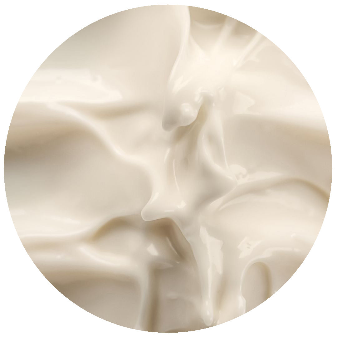 Close-up view of a creamy, smooth, off-white substance with soft folds and glossy texture, resembling yogurt or lotion.
