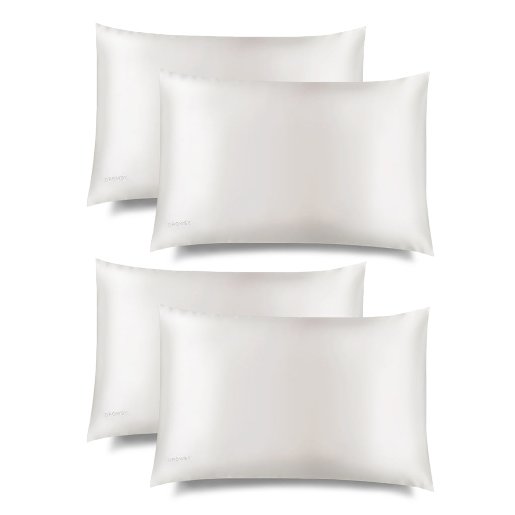 Four white Akoya Pearl Silk Pillowcases by us.drowsysleepco are arranged in two rows on a white background. The smooth silk fabric is gentle on skin and hair, providing skincare benefits and hair protection.