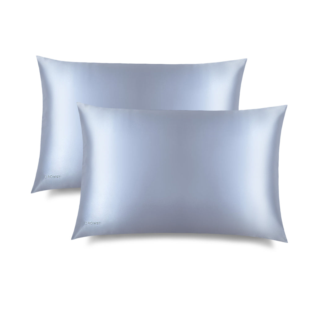 Two Blue Belle Silk Pillowcases by us.drowsysleepco are shown on a white background, one partially overlapping the other—ideal for hair protection and enhancing your beauty routine.