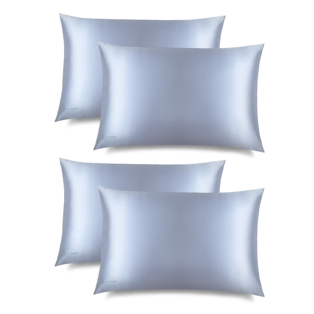 Four Blue Belle Silk Pillowcases by us.drowsysleepco are arranged in two rows on a white background, showcasing their smooth, shiny light blue finish with subtle embroidered text in one corner.