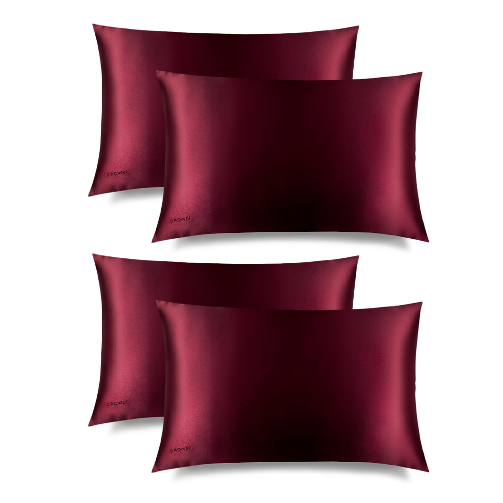Four La Vie En Rouge Silk Pillowcases by us.drowsysleepco, shown on a white background, feature a smooth, shiny dark red finish—luxurious essentials for hair protection and skincare in your nighttime routine.