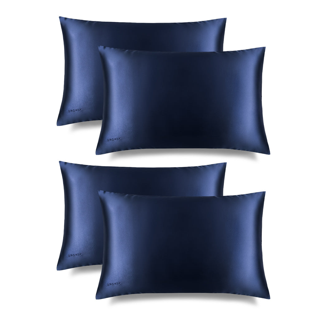Four us.drowsysleepco Midnight Blue Silk Pillowcases are arranged in two rows against a white background. Each smooth, hair-protecting pillowcase features a subtle sheen and small logo, ideal for skincare and beauty routines.