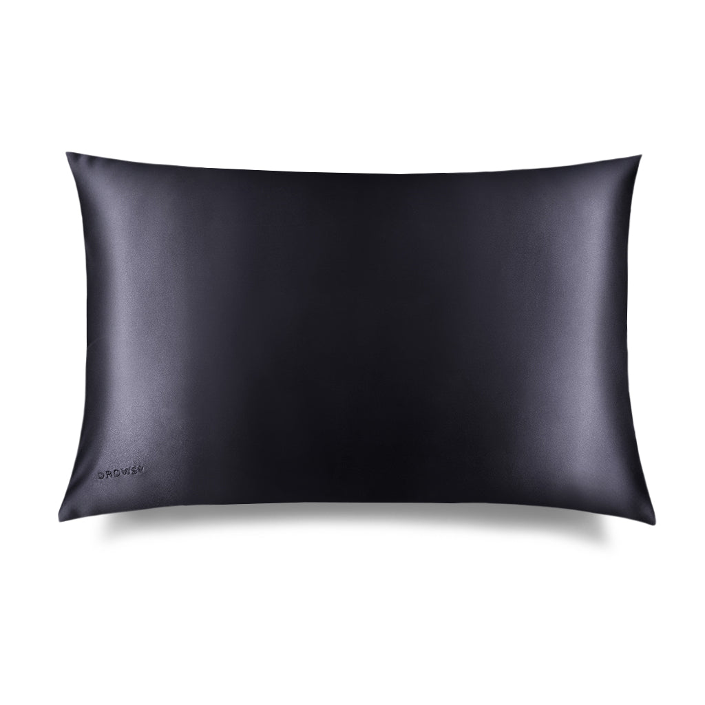 The Moonlight Shadow Silk Pillowcase by us.drowsysleepco features a smooth black rectangular design with a subtle sheen, ideal for skin and hair care, and has "DROUZZE" discreetly printed on the bottom left against a white background.