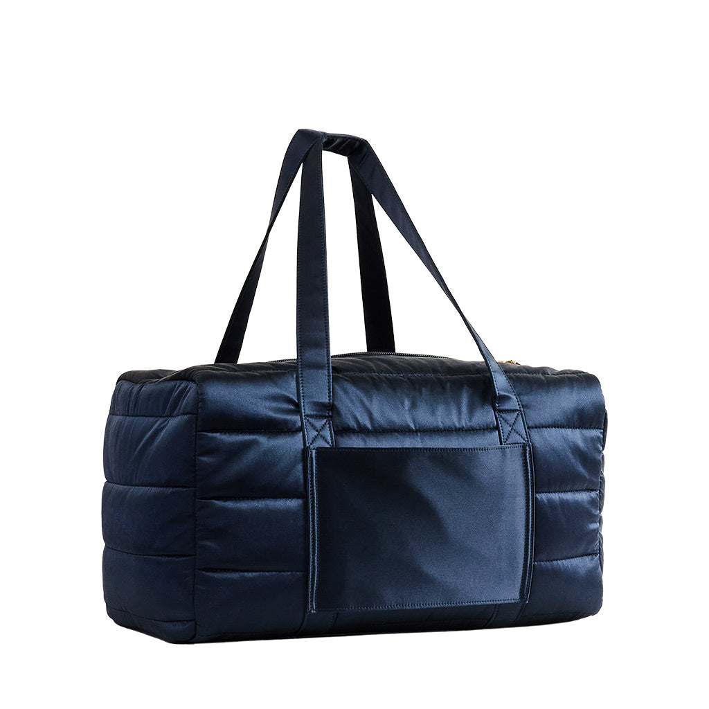 The Drowsy Silk Weekender - Midnight Blue by Drowsy is a large, rectangular quilted bag with double handles and a front pocket, ideal for travel essentials, showcased against a plain white background.