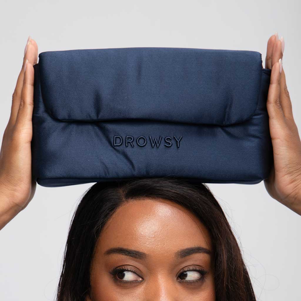 A person holds the Drowsy Weekend Collection - Midnight Blue + Damask Rose pouch on their head, showing only their forehead, eyes, and hands against a plain background.