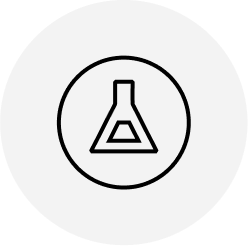 Black outline of a laboratory flask inside a circle, centered on a light gray circular background. The flask icon symbolizes science or chemistry.