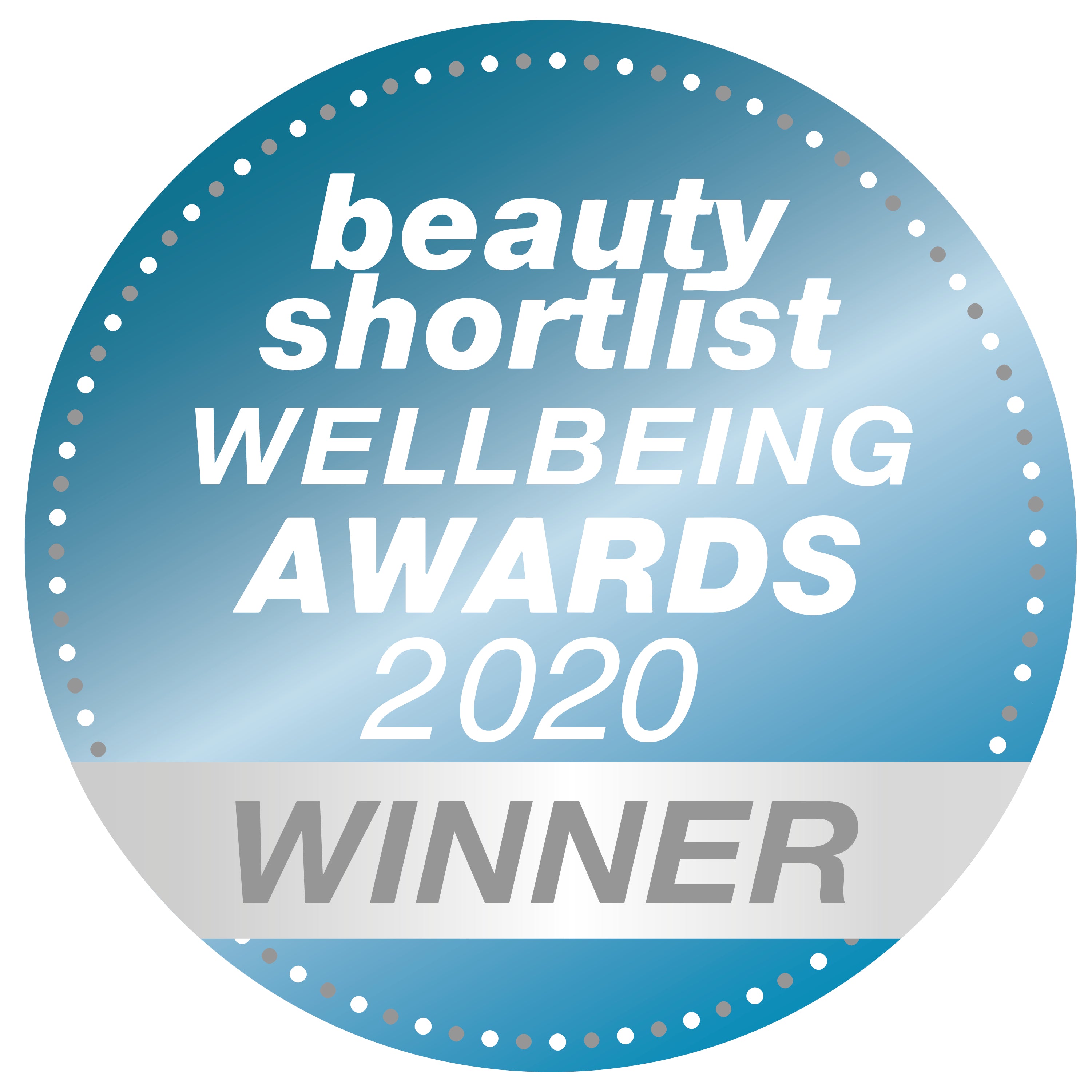 A round blue badge with white text reads beauty shortlist WELLBEING AWARDS 2020 and WINNER in bold silver letters on a silver ribbon at the bottom. The edge is decorated with white dots.