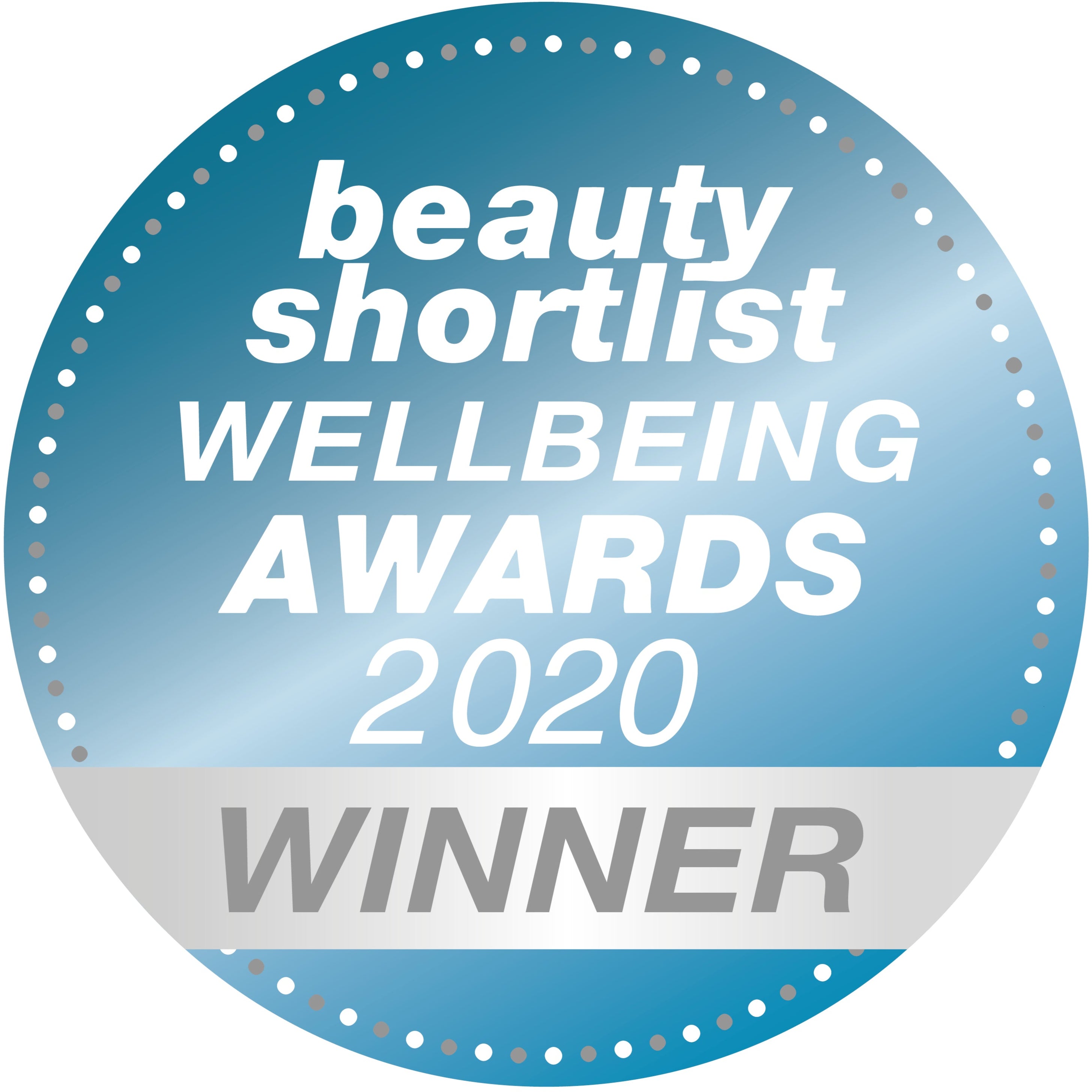A round blue badge with white text that reads beauty shortlist WELLBEING AWARDS 2020 and a silver band at the bottom says WINNER. The edge is decorated with small white dots.