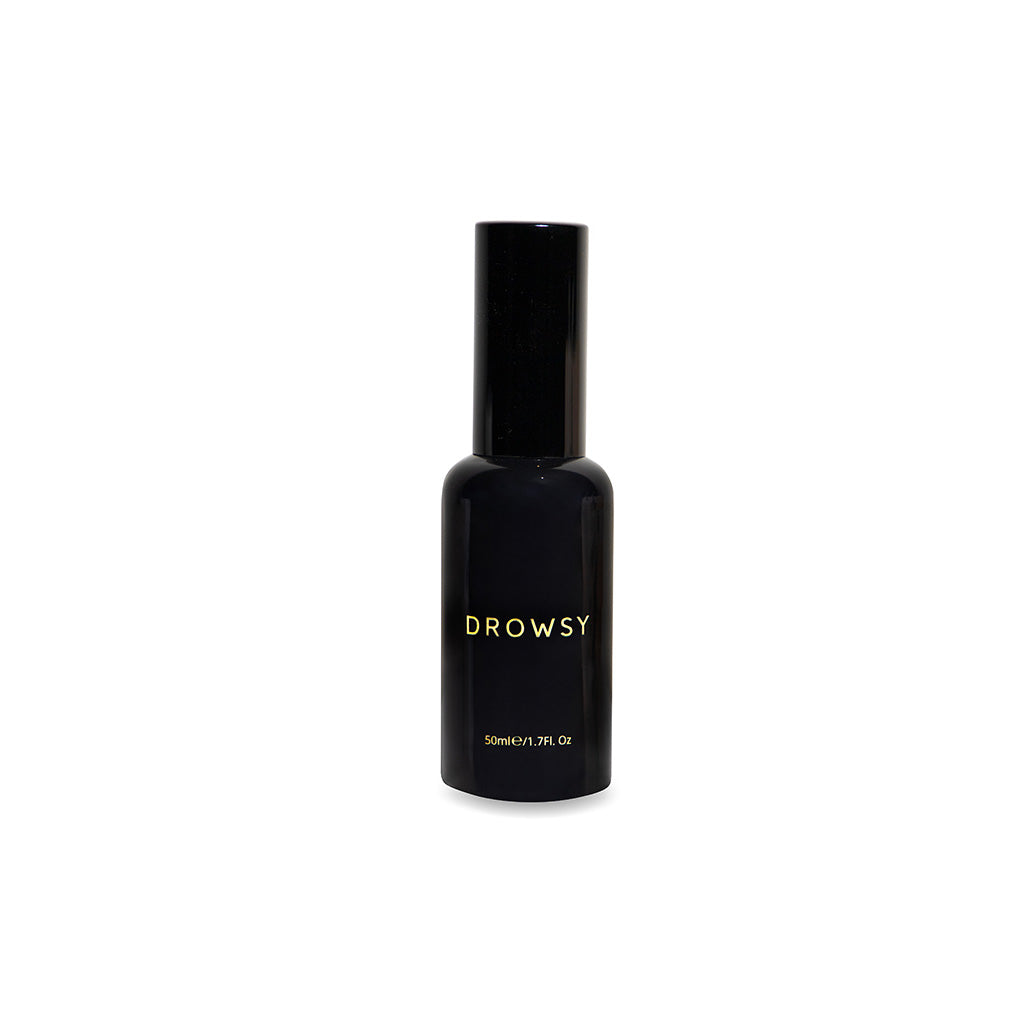 A black Sleep S.O.S Pillow Spray by us.drowsysleepco features gold "Drowsy" lettering, a rounded body, and tall cap. On a white background, this 50ml/1.7FL Oz natural spray supports restful sleep as part of your night ritual.